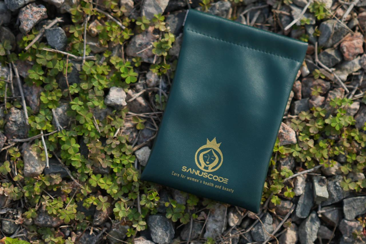 6x4inch green pu leather pouch lays on crushed stones in the sunset
