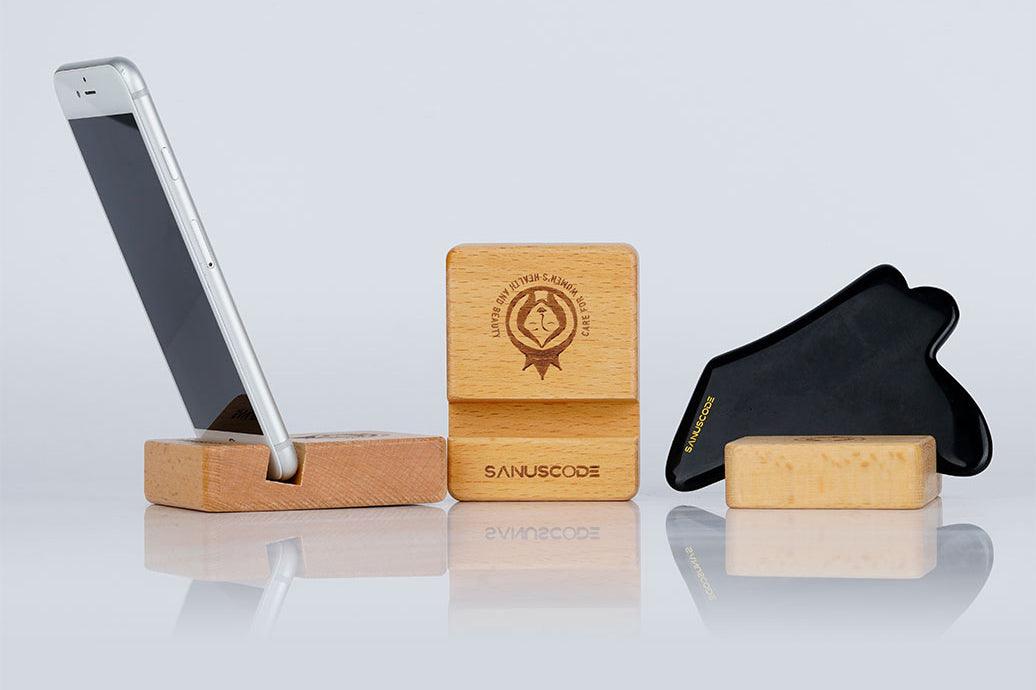 iphone and black facial gua sha stone stand on wood holders